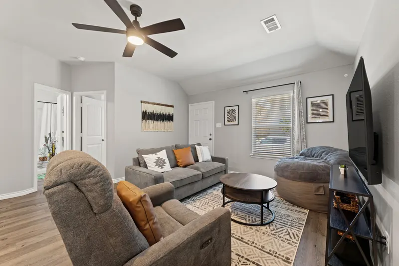 Living room with sectional sofa, oversized bean bag, round coffee table and smart TV